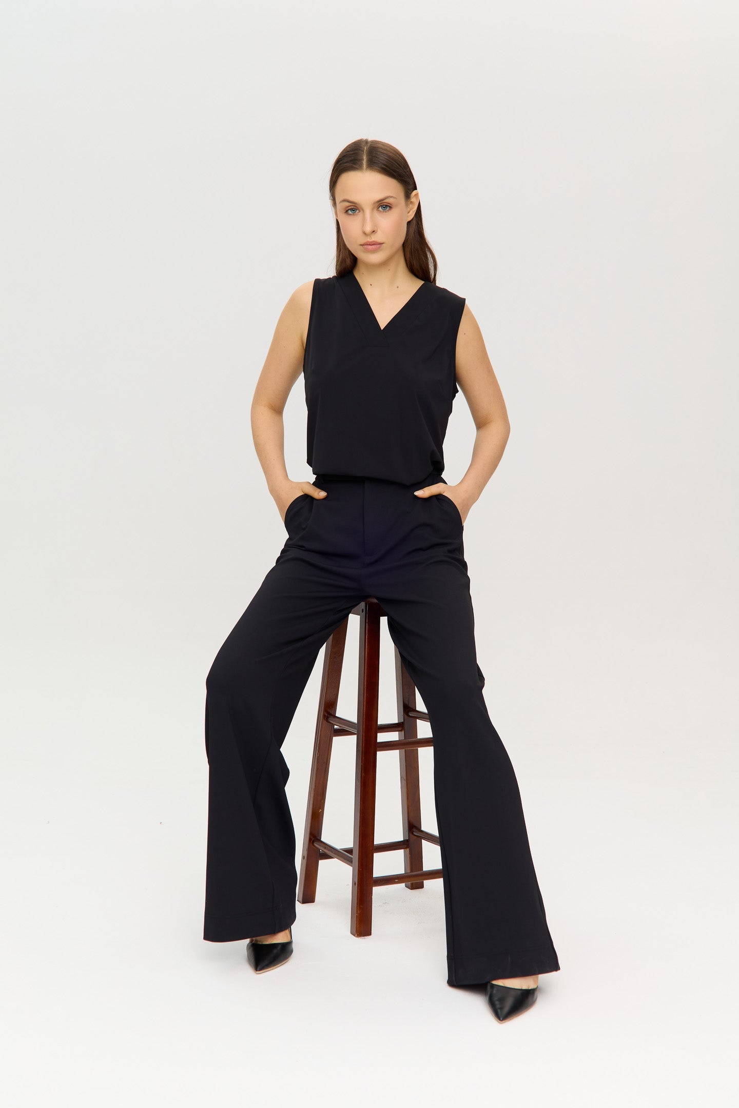 Black Sleeveless V-neck halter top in a soft, stretchy fabric, worn by a model.